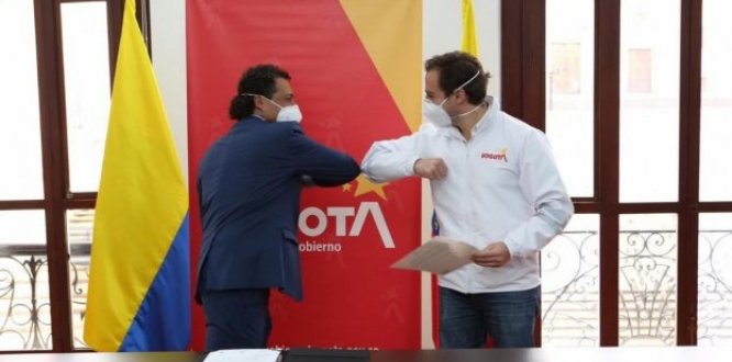 Alcalde local saludando de codo con el secretario de gobierno
